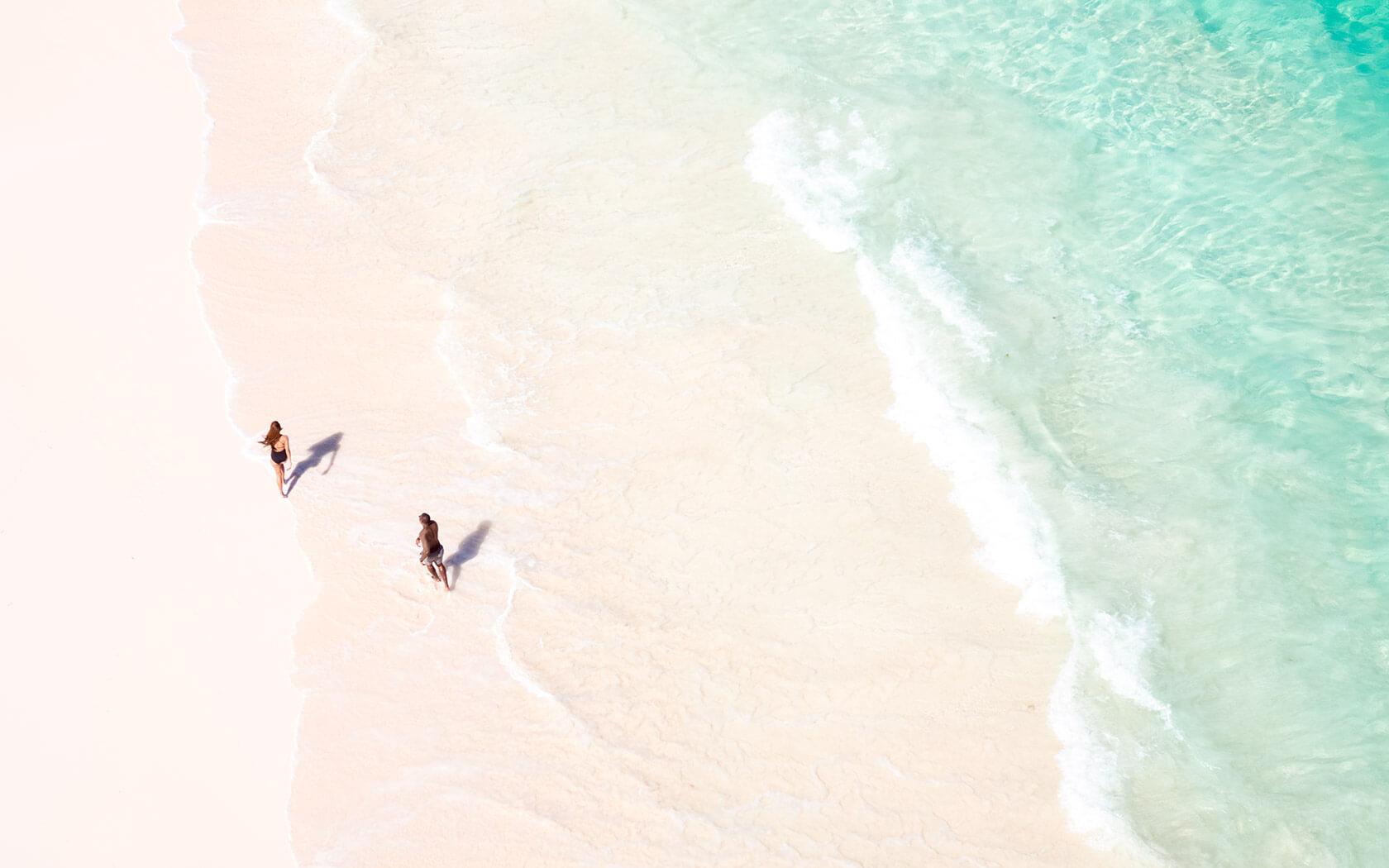 aerial view of two people running on beach