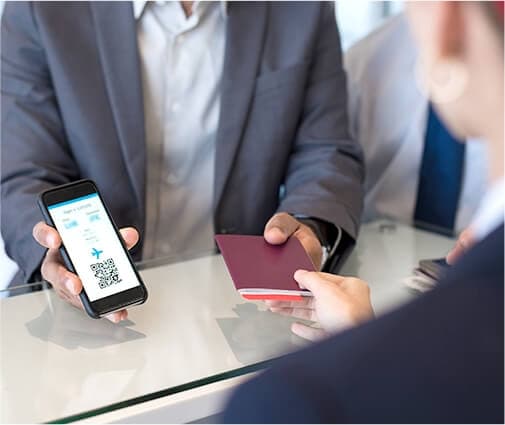 person showing a desk clerk their ticket and phone app